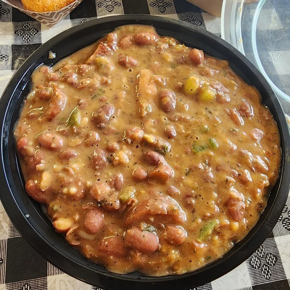 A close-up of a black bowl filled with A Taste of New Orleans' red beans and rice.