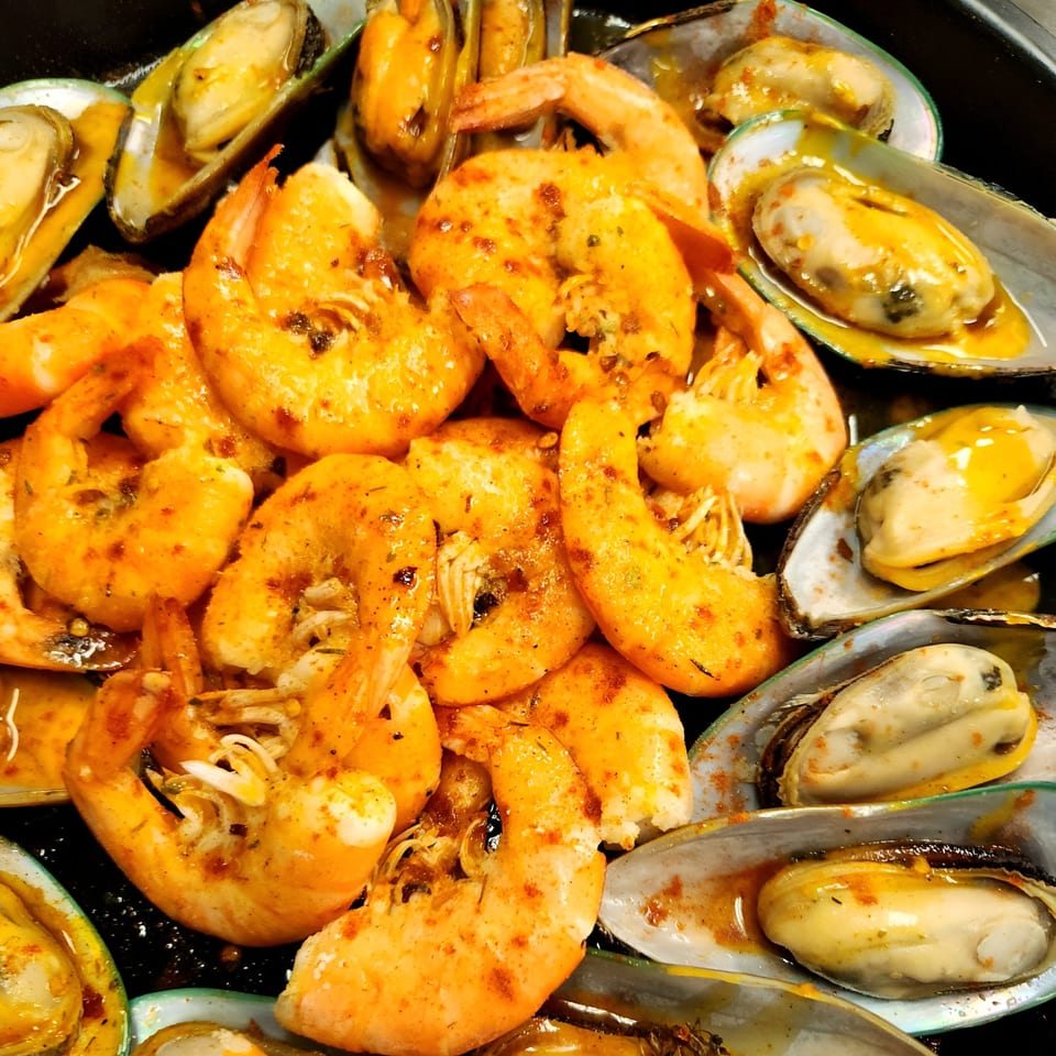 Cajun-spiced shrimp and mussels in a rich sauce, ready to be enjoyed at A Taste of New Orleans.