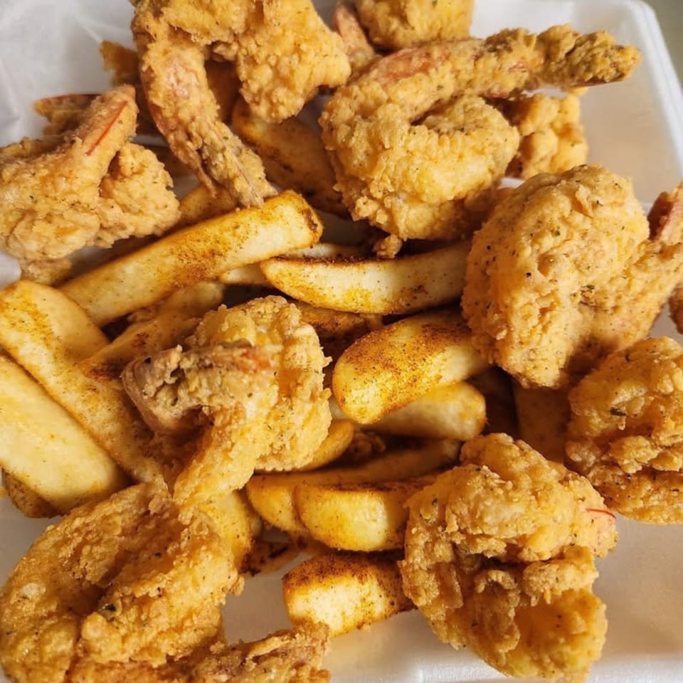 Close-up of golden-fried shrimp and seasoned potato wedges from A Taste of New Orleans.